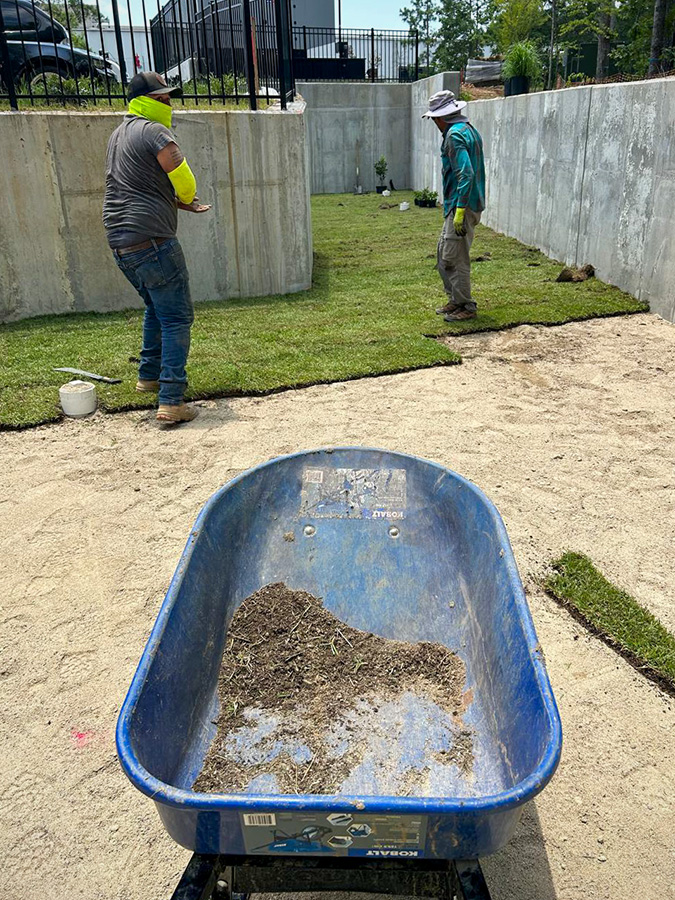 East Coast Civil Group workers lay sod in the basin of a bioretention pond.