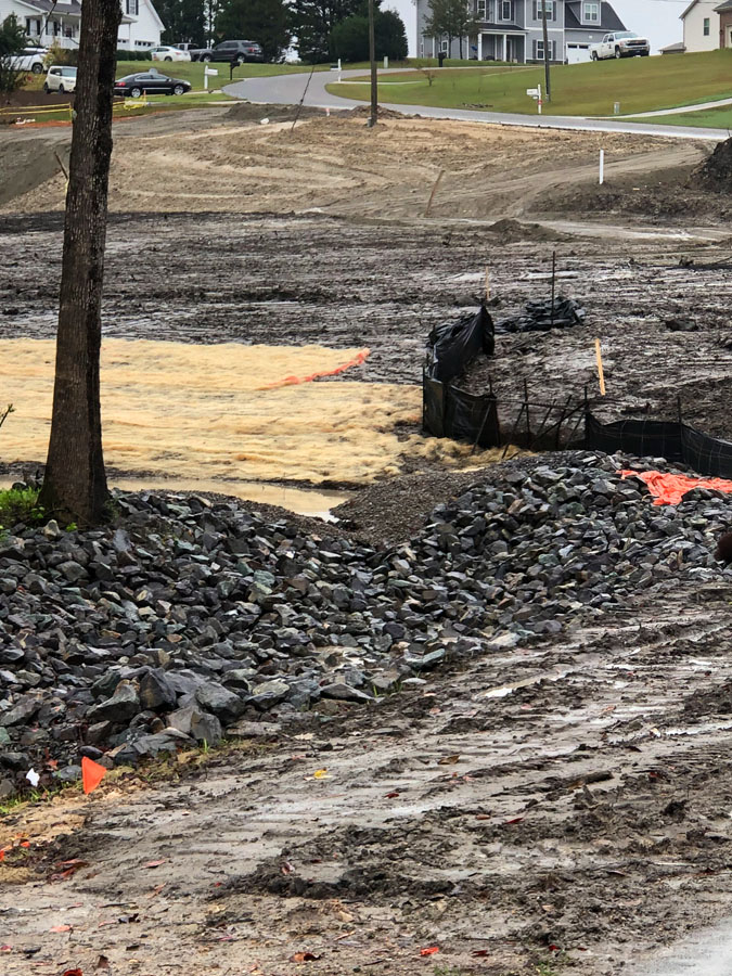 Site preparation work for lot remediation involves excavating and clearing land, removing material, and grading it for optimal stormwater runoff.